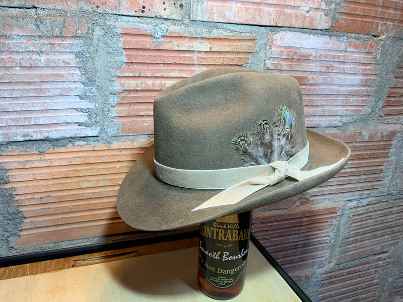 Fedora hat pictured in Pecan with a velvet hatband and custom feather embellishment.